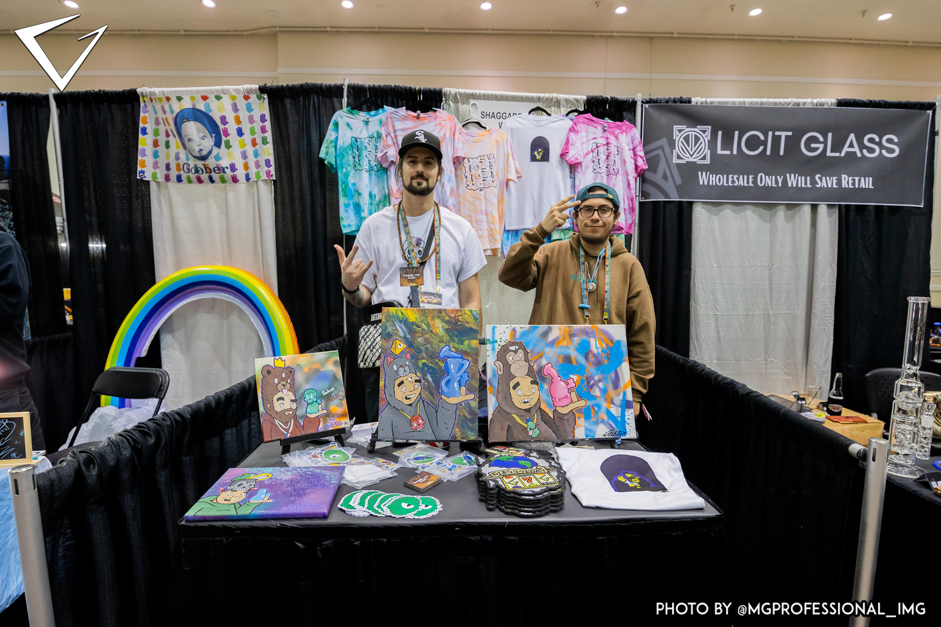 Artists at booth posing on show floor